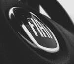 Detailed black and white image of a Fiat car emblem on a steering wheel interior.